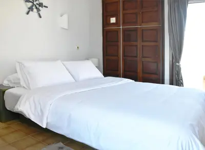 a bedroom with two white beds and a wooden door at Modern Apartment with Stunning Piraeus Views in Piraeus
