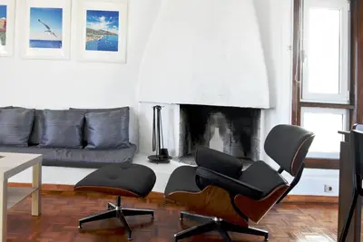 a living room with two chairs and a fireplace at Modern Apartment with Stunning Piraeus Views in Piraeus