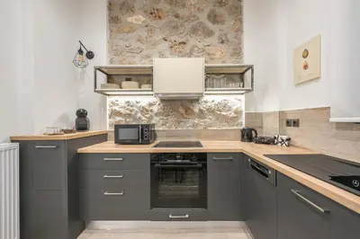a kitchen with gray cabinets and a counter top at PetraLab By Greece Apartments in Athens