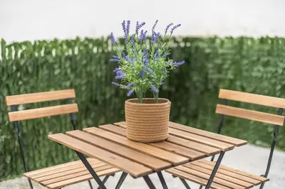 a wooden table with a vase with purple flowers on it at PetraLab By Greece Apartments in Athens