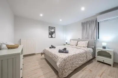 a white bedroom with a bed and a window at PetraLab By Greece Apartments in Athens