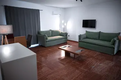 a living room with two green couches and a coffee table at Grec Maison Piraeus by GrecCollection in Piraeus