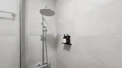 a bathroom with a shower with a shower head at Grec Maison Piraeus by GrecCollection in Piraeus