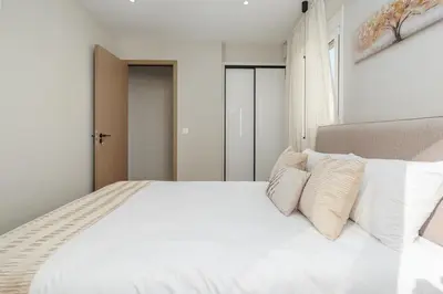 a bedroom with a white bed with white pillows at Brand New Building Deluxe Apartments With Parking Nearby Train in Athens