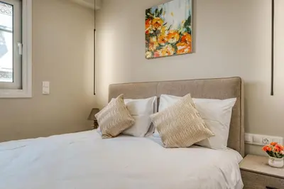 a bedroom with a bed with white sheets and pillows at Brand New Building Deluxe Apartments With Parking Nearby Train in Athens