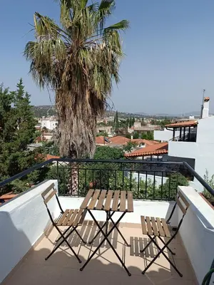 two chairs and a table on a balcony with a palm tree at ATH Airport, Loft in Painia in Paianía