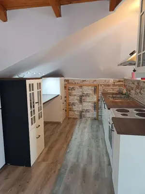 a kitchen with white cabinets and a counter top at ATH Airport, Loft in Painia in Paianía