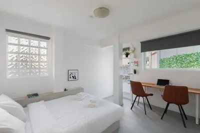 a white bedroom with a bed and a desk at Top Floor Stunning Acropolis View in Athens