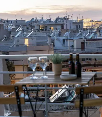 a table with wine glasses on top of a balcony at Top Floor Stunning Acropolis View in Athens