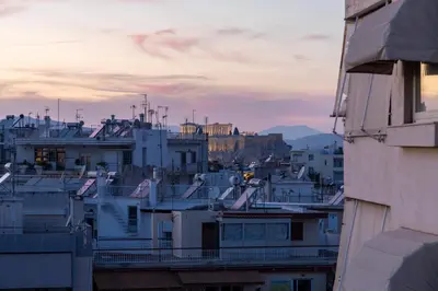 a view of a city at sunset with buildings at Top Floor Stunning Acropolis View in Athens