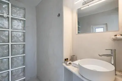 a white bathroom with a sink and a mirror at Top Floor Stunning Acropolis View in Athens
