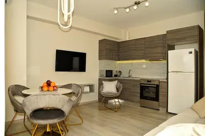 a kitchen with a table and a white refrigerator at Sunset Haven Piraeus in Piraeus