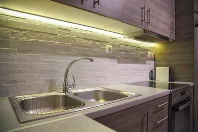a kitchen with a stainless steel sink and cabinets at Sunset Haven Piraeus in Piraeus