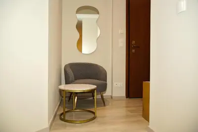 a chair in a hallway with a table and a stool at Sunset Haven Piraeus in Piraeus