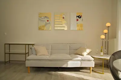 a living room with a couch and two paintings on the wall at Sunset Haven Piraeus in Piraeus