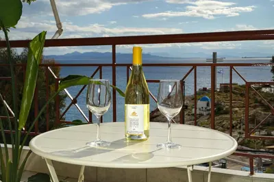 a bottle of wine sitting on a table with two glasses at Sunset Haven Piraeus in Piraeus
