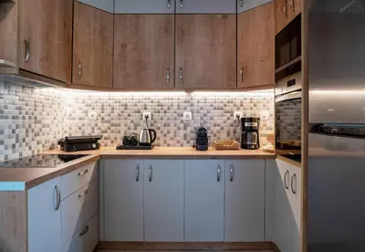 a kitchen with wooden cabinets and white appliances at Acropolis Penthouse Project in Athens