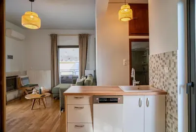 a kitchen and a living room with a couch at Acropolis Penthouse Project in Athens