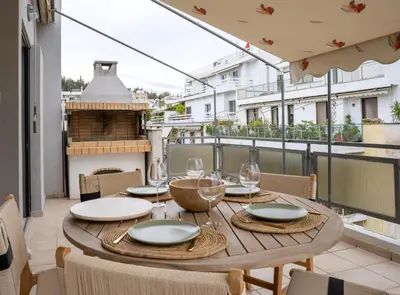 a table with wine glasses on a balcony at Acropolis Penthouse Project in Athens