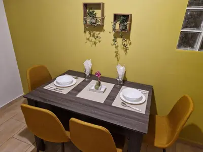 a dining room table with chairs and plates on it at SYGGROU - ONASSIO and REA Hospitals - 1bdr APT - sleep 2-4p in Athens