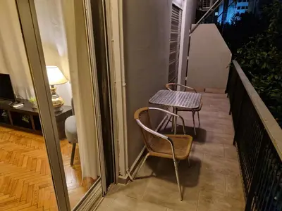 a small table and two chairs on a balcony at SYGGROU - ONASSIO and REA Hospitals - 1bdr APT - sleep 2-4p in Athens