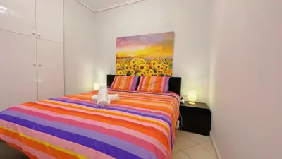 a bedroom with a colorful bed with a stuffed animal on it at LiI\u7684\u516c\u5bd3\u79bb\u6d771\u5206\u949f Ps5 macPC sony\u7535\u89c6 \u8212\u9002\u5927\u5e8a\u8bb0\u5fc6\u5e8a\u57ab \u6e38\u620f\u5f71\u89c6\u4f11\u95f2\u516c\u5bd3 \u9152\u5e97\u7528\u54c1 in Piraeus