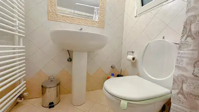 a bathroom with a white toilet and a sink at LiI\u7684\u516c\u5bd3\u79bb\u6d771\u5206\u949f Ps5 macPC sony\u7535\u89c6 \u8212\u9002\u5927\u5e8a\u8bb0\u5fc6\u5e8a\u57ab \u6e38\u620f\u5f71\u89c6\u4f11\u95f2\u516c\u5bd3 \u9152\u5e97\u7528\u54c1 in Piraeus