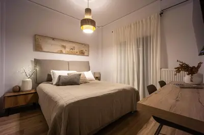 a bedroom with a bed and a wooden table at Ariston!Μικρο ρετιρέ στο Θησείο in Athens