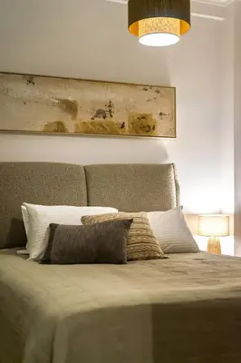 a bedroom with a bed with a painting on the wall at Ariston!Μικρο ρετιρέ στο Θησείο in Athens