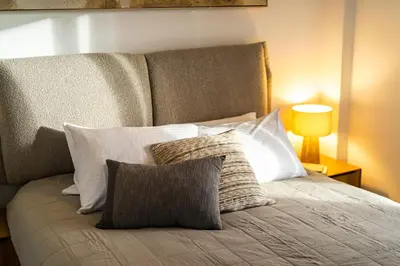 a bedroom with a bed with pillows and a lamp at Ariston!Μικρο ρετιρέ στο Θησείο in Athens