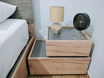 a bedside drawer with a nightstand with a clock and a lamp at MYKALI's COZY APARTMENT in Athens