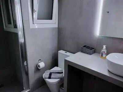 a bathroom with a white toilet and a sink at MYKALI's COZY APARTMENT in Athens