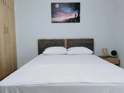 a bedroom with a large white bed with a picture on the wall at MYKALI's COZY APARTMENT in Athens