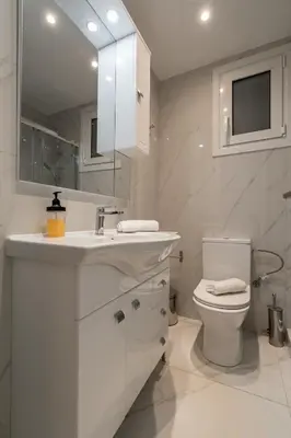 a white bathroom with a sink and a toilet at City Center Balcony Escape in Athens