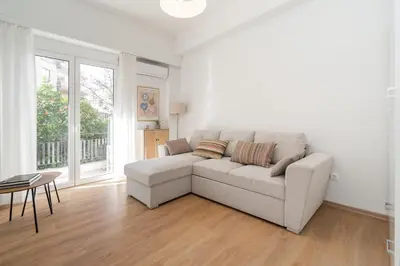 a living room with a couch and a table at City Center Balcony Escape in Athens