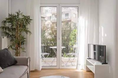 a living room with a tv and a balcony at City Center Balcony Escape in Athens