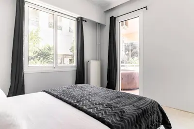 a bedroom with a bed and two windows at Eclipse Riviera Cosy in Athens