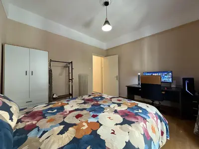 a bedroom with a bed with a colorful comforter at Yu\u7684\u516c\u5bd3 \u5730\u94c1\u9644\u8fd12\u4e2a\u5927\u5e8a\u623f\u7535\u7ade\u6e38\u620f\u4f11\u95f2\u9152\u5e97\u516c\u5bd3\u5546\u4e1a\u8857\u8d85\u5e02\u8f7b\u8f68\u6e2f\u53e3\u673a\u573a\u76f4\u8fbe in Piraeus