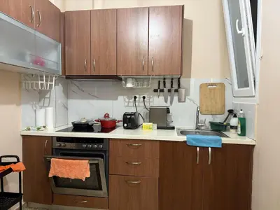 a kitchen with wooden cabinets and a stove top oven at Yu\u7684\u516c\u5bd3 \u5730\u94c1\u9644\u8fd12\u4e2a\u5927\u5e8a\u623f\u7535\u7ade\u6e38\u620f\u4f11\u95f2\u9152\u5e97\u516c\u5bd3\u5546\u4e1a\u8857\u8d85\u5e02\u8f7b\u8f68\u6e2f\u53e3\u673a\u573a\u76f4\u8fbe in Piraeus