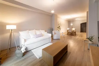 a living room with a white couch and a table at Athenian Heaven in Athens