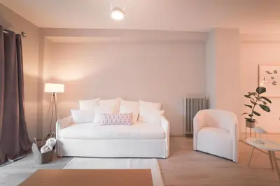a bedroom with a white bed and a chair at Athenian Heaven in Athens