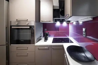 a kitchen with purple walls and white cabinets at Athenian Heaven in Athens