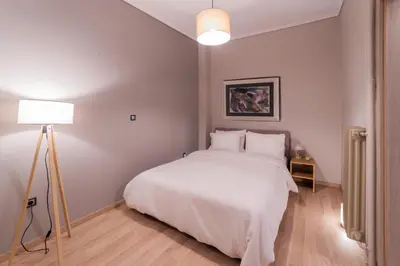 a bedroom with a white bed and a lamp at Athenian Heaven in Athens