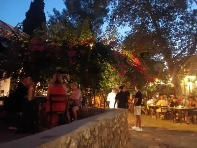 a group of people sitting in a garden at night at Spacious apartment near Acropolis in Athens