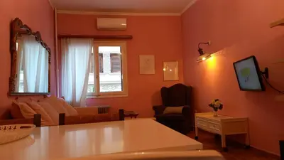 a living room with orange walls and a table at Spacious apartment near Acropolis in Athens