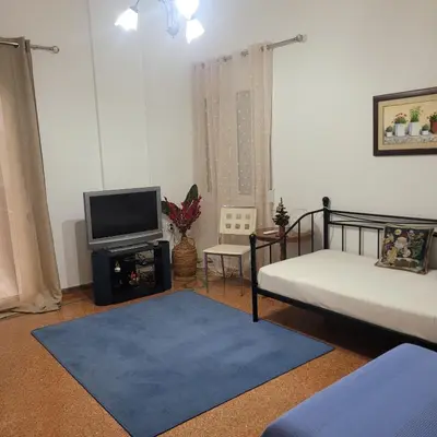 a living room with two beds and a tv at Casa Bulu in Athens