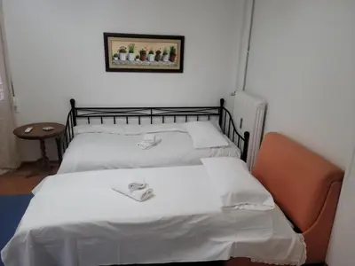 a bedroom with two beds and a picture on the wall at Casa Bulu in Athens