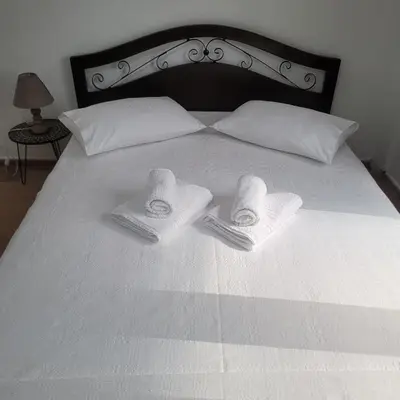 a bed with two towels and two pillows on it at Casa Bulu in Athens