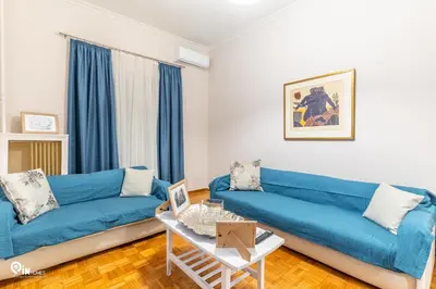 a living room with a blue couch and a table at Sophocles - Central Athenian Cozy Retreat in Athens