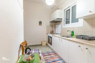 a kitchen with white cabinets and a sink at Sophocles - Central Athenian Cozy Retreat in Athens